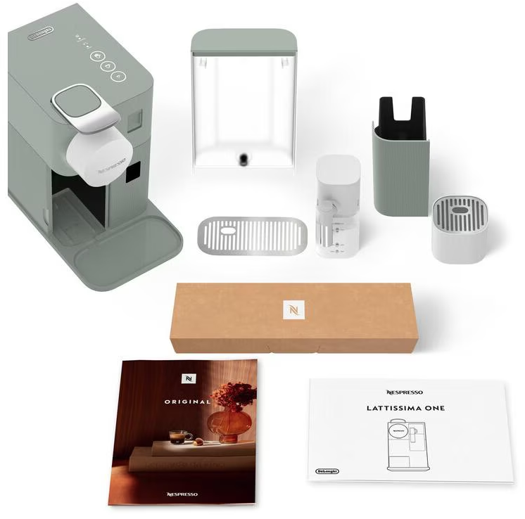 Une machine à café Nespresso et ses accessoires, dont un réservoir d'eau, un égouttoir et un manuel.