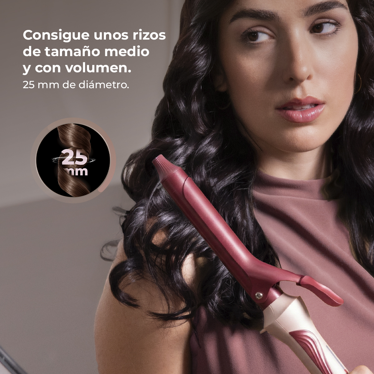 Una mujer con pelo rizado oscuro sostiene un rizador rojo. Un rizo de "25 mm" se muestra en un círculo.