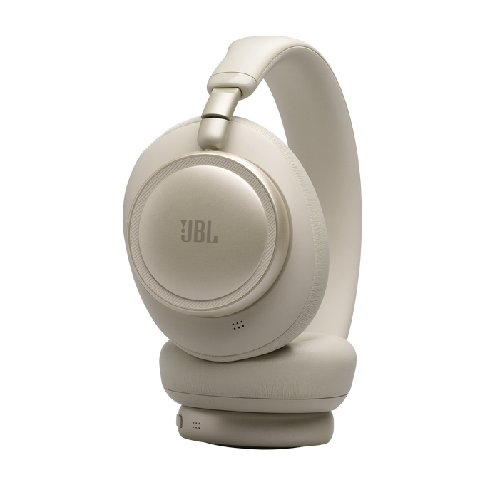 Unos auriculares JBL beige con diadema y almohadillas sobre fondo negro.