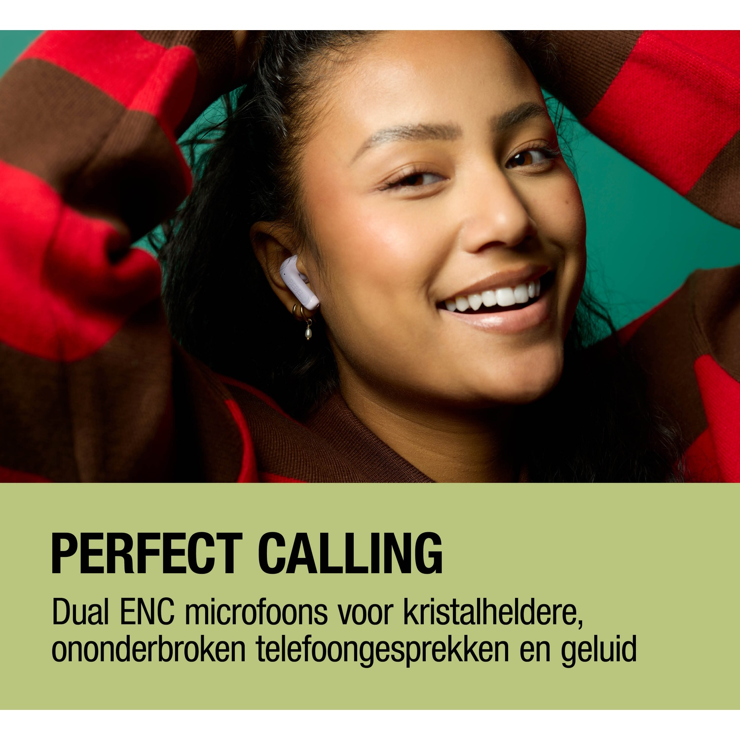 Een vrouw met oordopjes glimlacht, gekleed in een gestreepte trui.