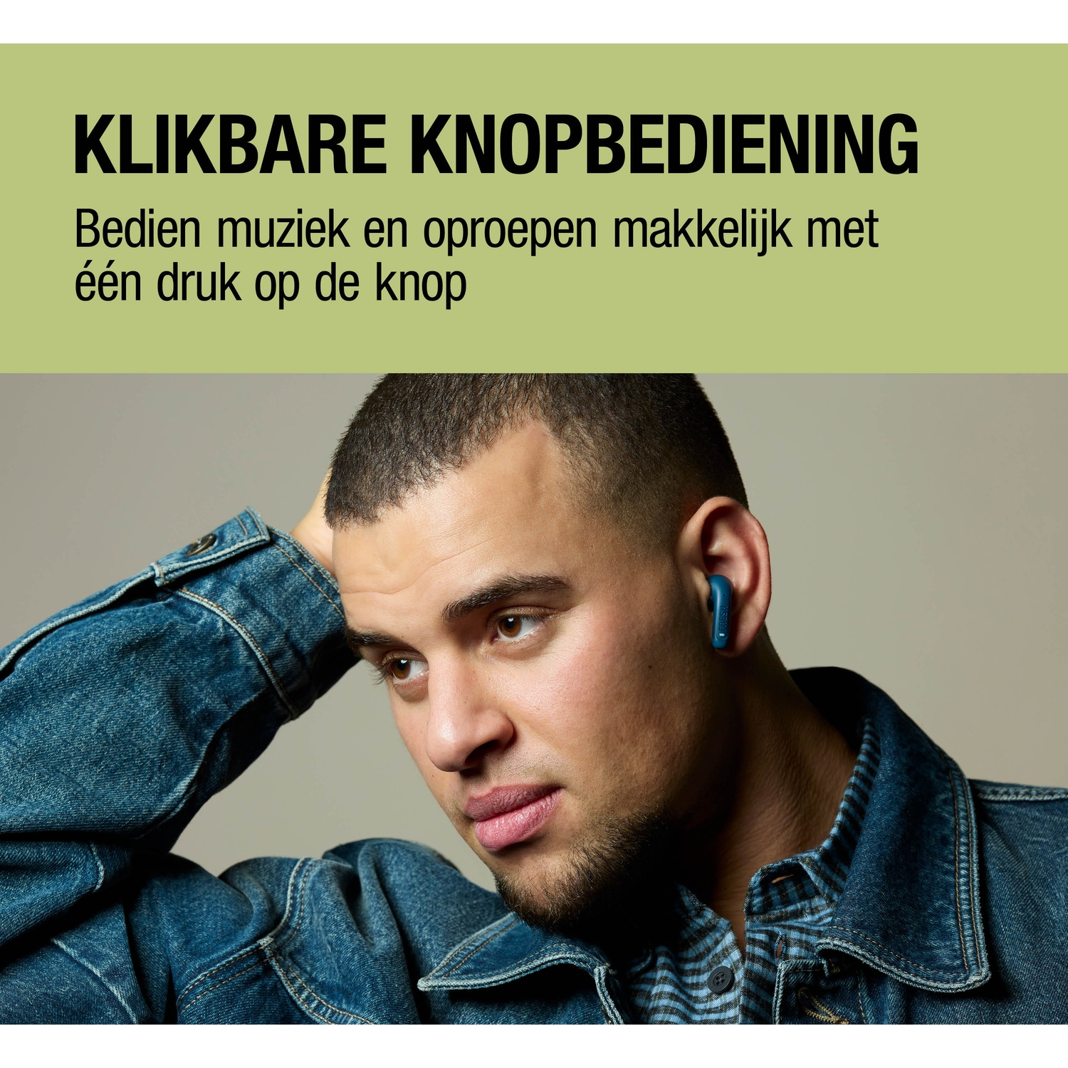 Man in spijkerjack met blauwe oordopjes, krabt aan zijn hoofd.
