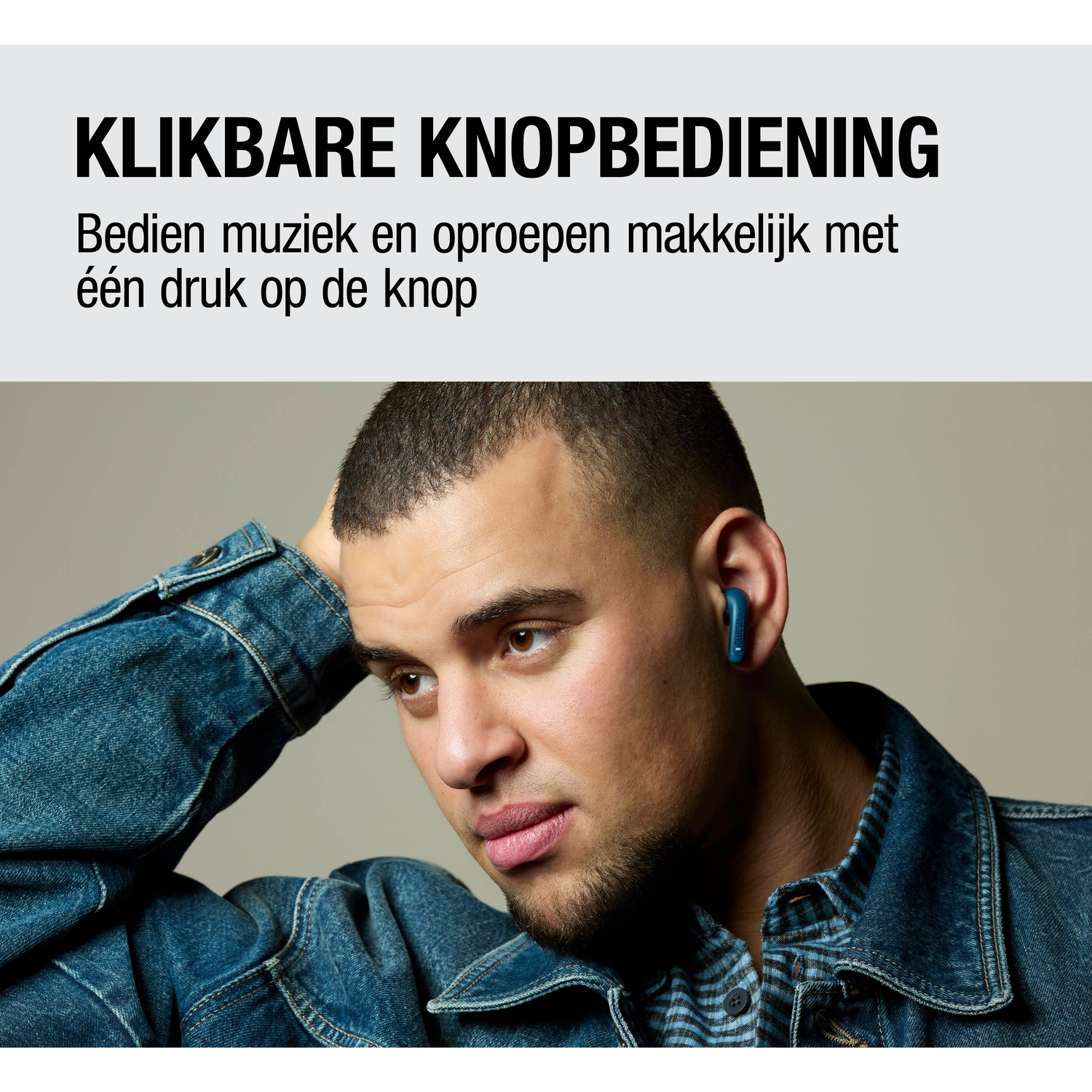Een man in een spijkerjasje draagt blauwe oordopjes. Hij legt zijn hand achter zijn hoofd.