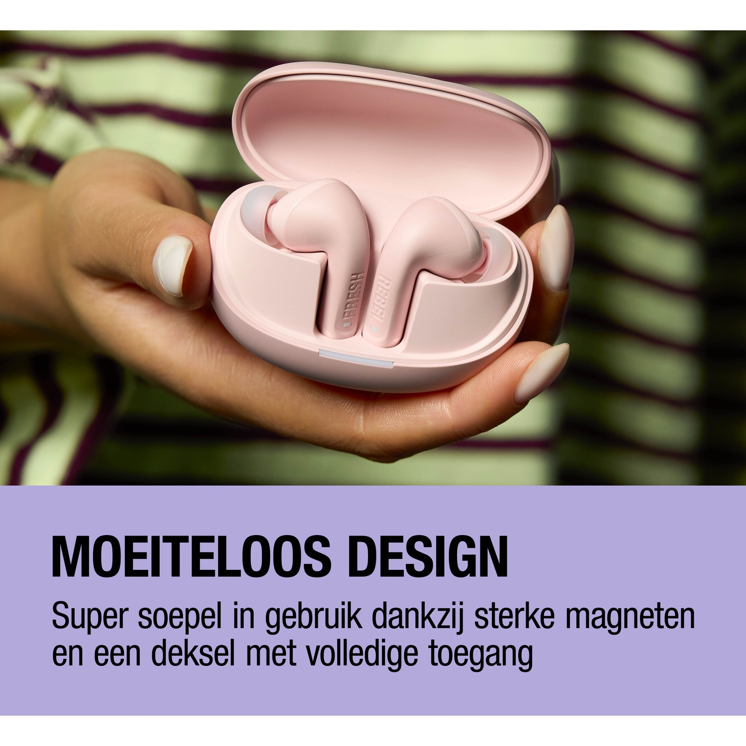 Een hand houdt een roze oplaaddoosje met oordopjes vast. De achtergrond is gestreept.