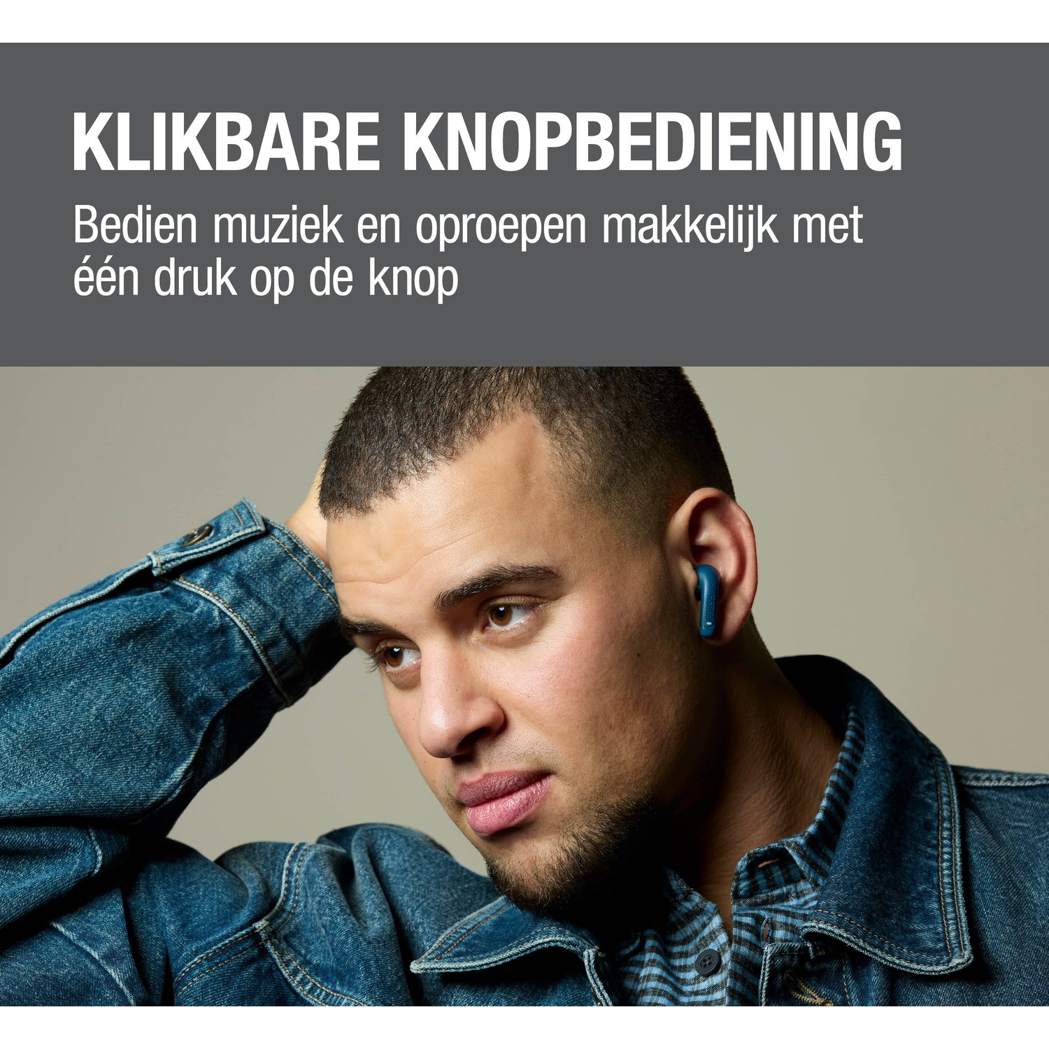 Man in spijkerjack draagt blauwe oordopjes. Hij legt een hand op zijn hoofd.