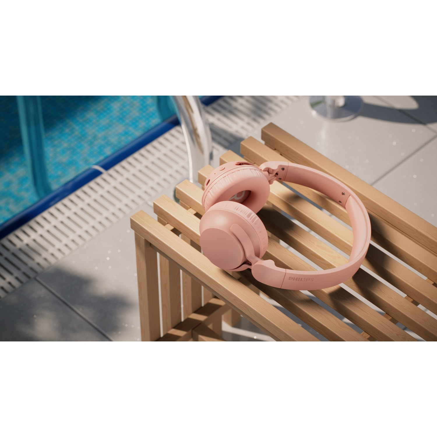 Cuffie rosa su una panca di legno accanto a una piscina.
