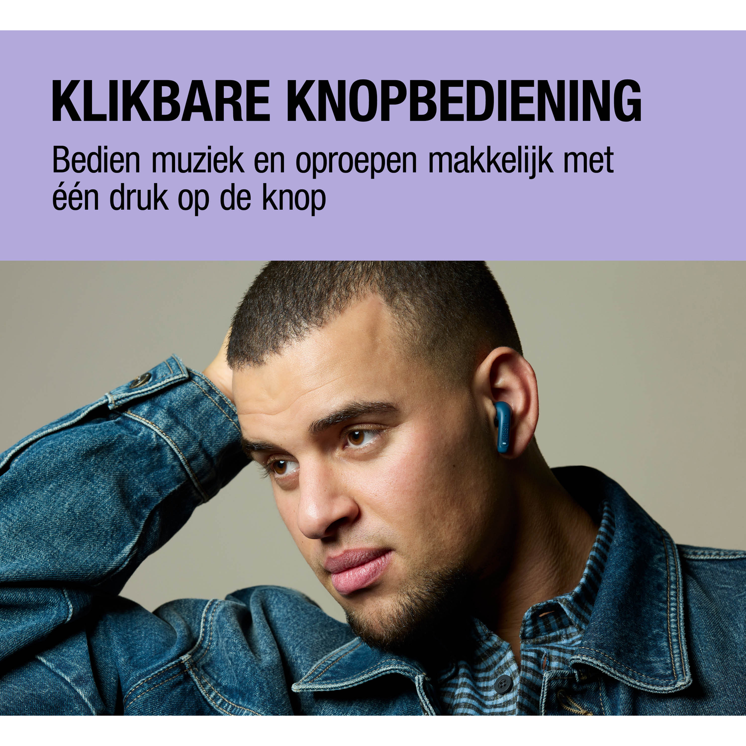 Man with blue earbuds in denim jacket, hand on head.