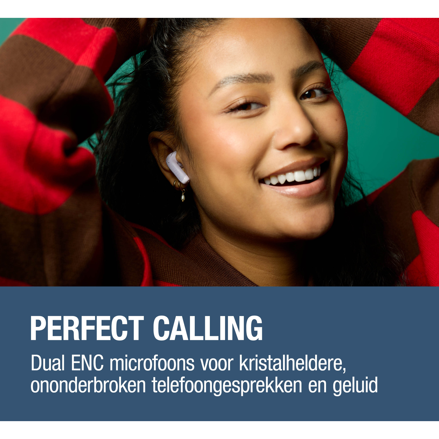 Woman smiles, wearing white earbuds, red sweater with brown stripes.