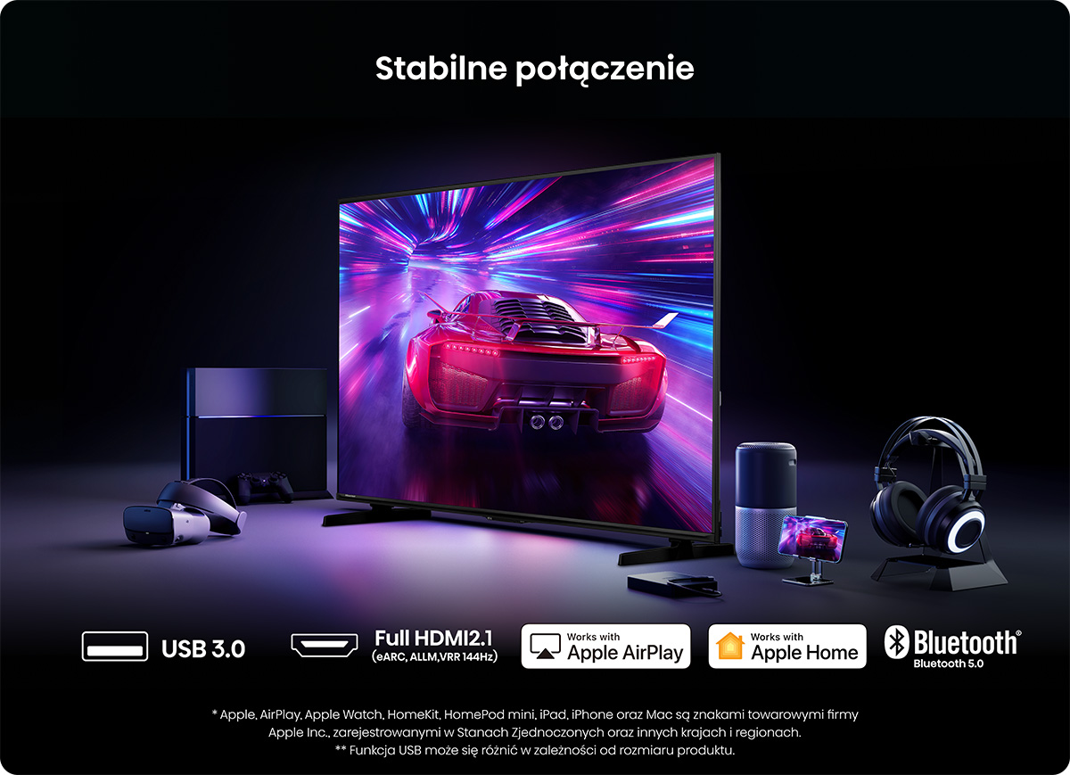 Telewizor z czerwonym samochodem sportowym na ekranie, obok konsola, gogle VR i słuchawki.