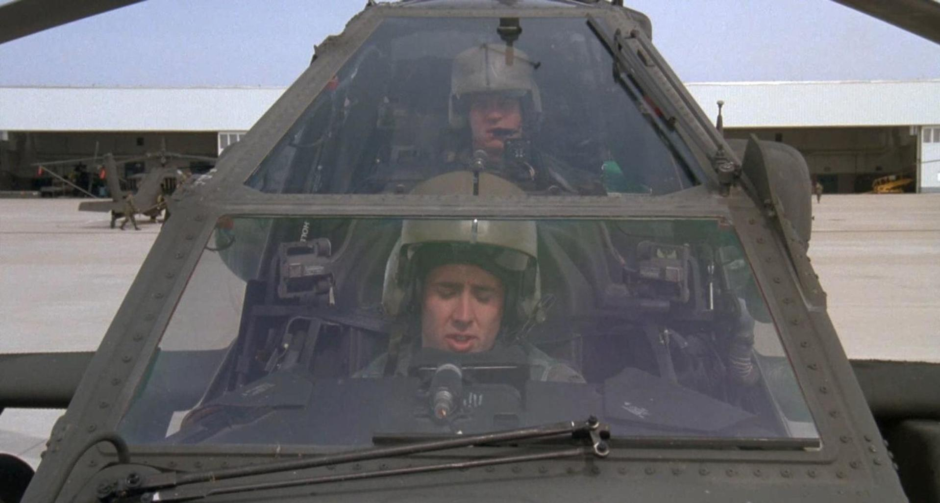 Zwei Piloten in einem Apache-Hubschrauber, die auf einem Flugplatz sitzen.