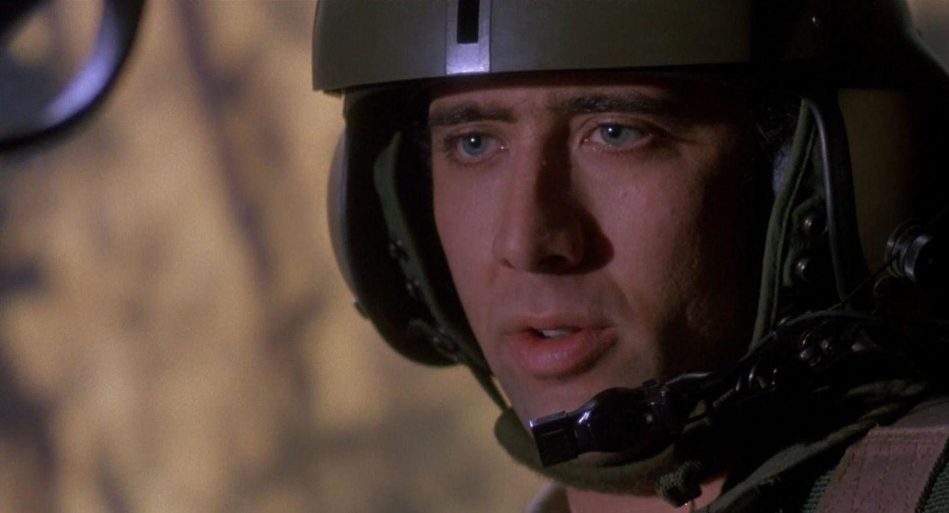 Mann in Militärhelm spricht, Nahaufnahme des Gesichts, unscharfer Hintergrund.