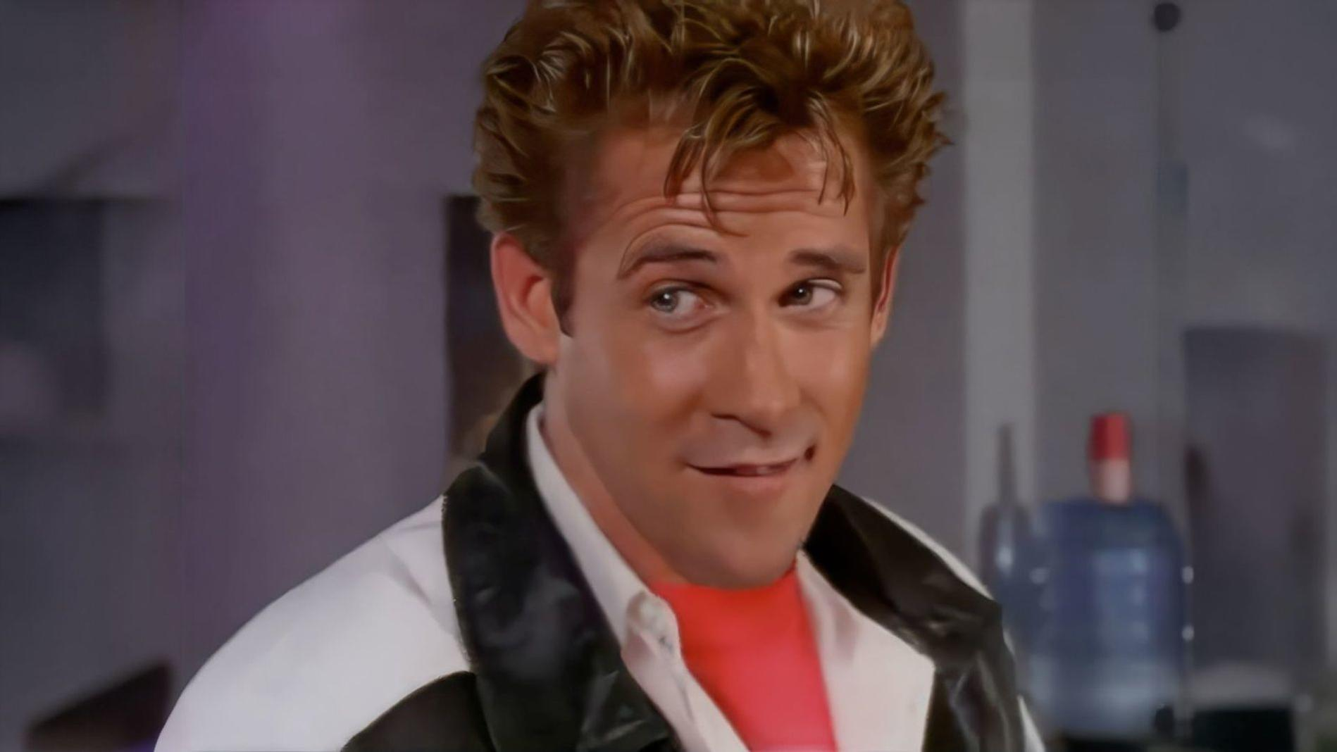 Ein Mann mit blondem Haar trägt eine Lederjacke und ein rotes Hemd.