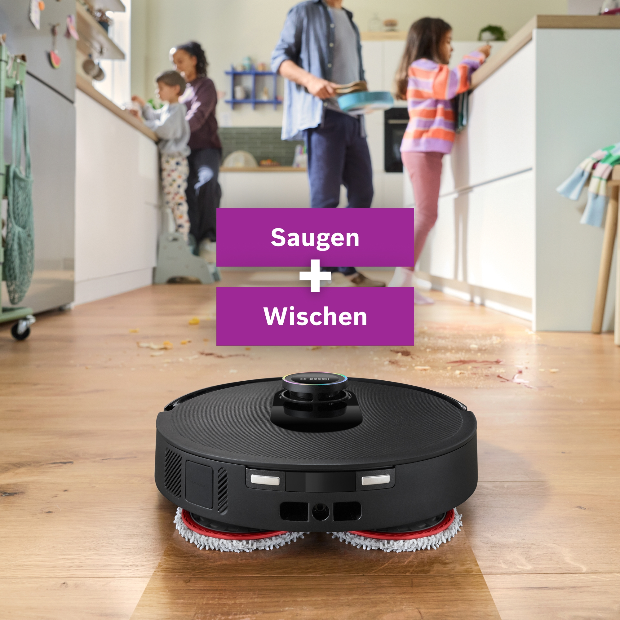 Ein Roboter-Staubsauger reinigt einen verschmutzten Holzboden in einer Küche, während eine Familie im Hintergrund beschäftigt ist.