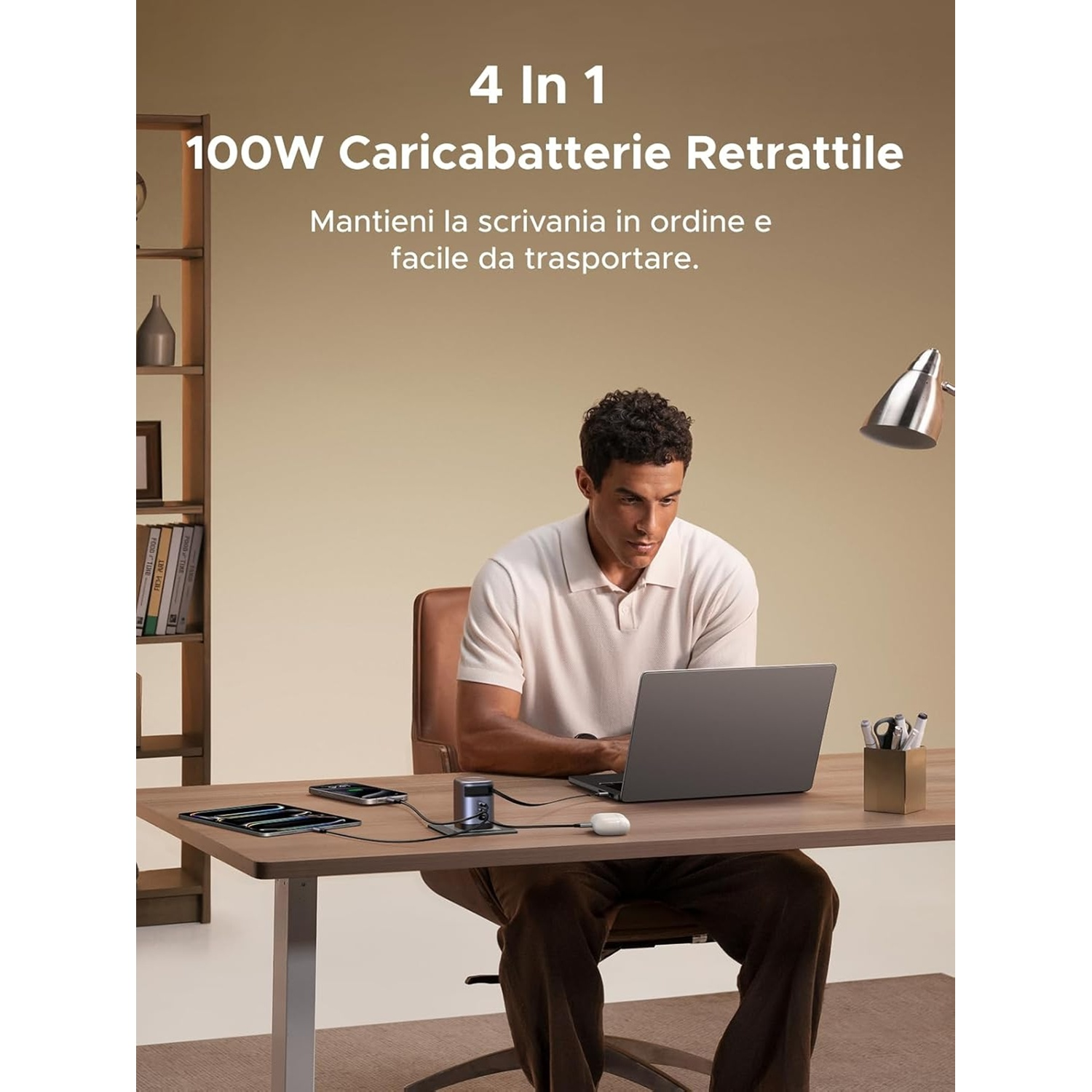 Uomo alla scrivania con laptop, tablet e telefono collegati a una stazione di ricarica 4 in 1.