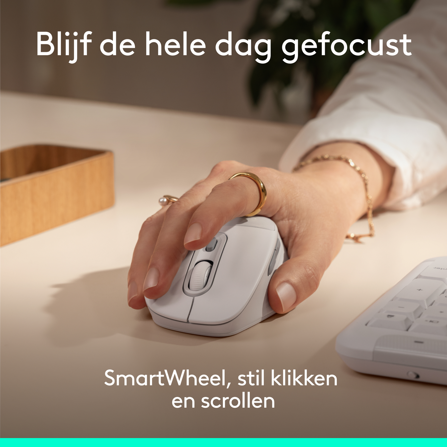A hand uses a white mouse next to a keyboard on a desk.