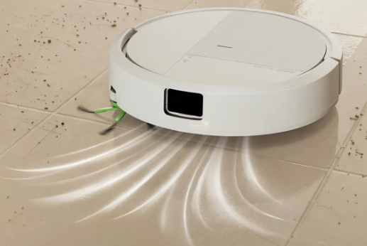 Biały robot sprzątający czyści brudną podłogę z płytek z widocznymi prądami powietrza.