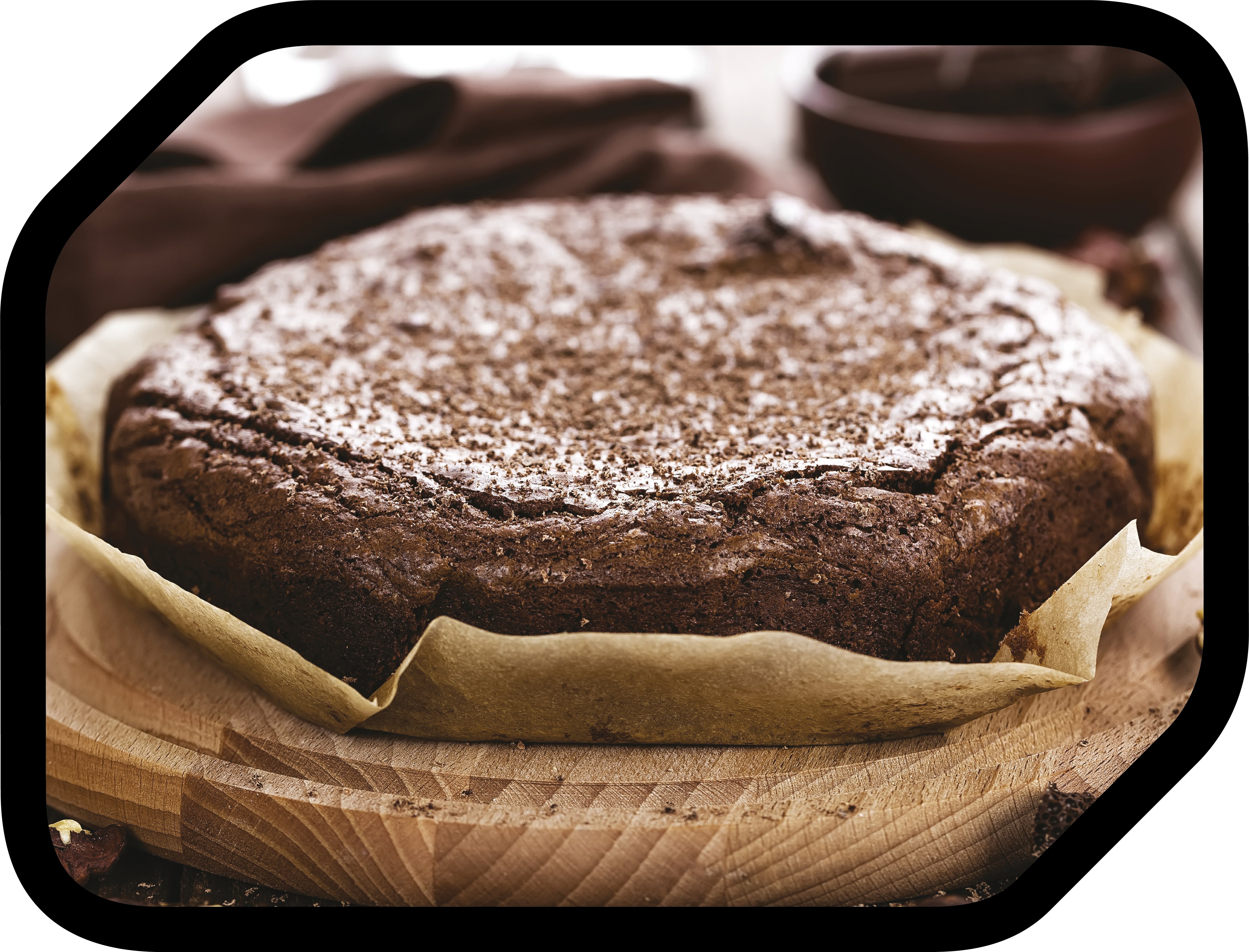Gâteau au chocolat saupoudré de sucre glace, sur planche en bois.
