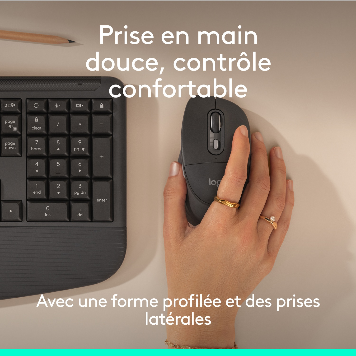 Une main tient une souris sombre à côté d'un clavier avec pavé numérique.