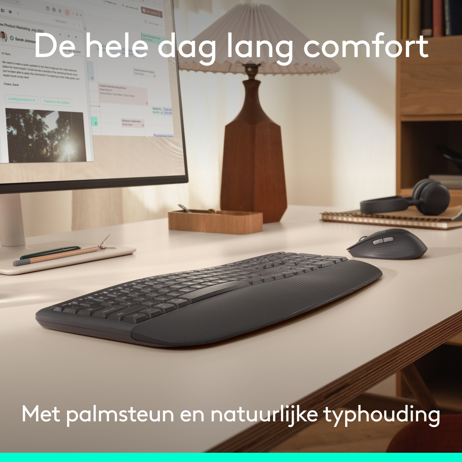 Ergonomic keyboard, mouse, headphones, and lamp on a desk.