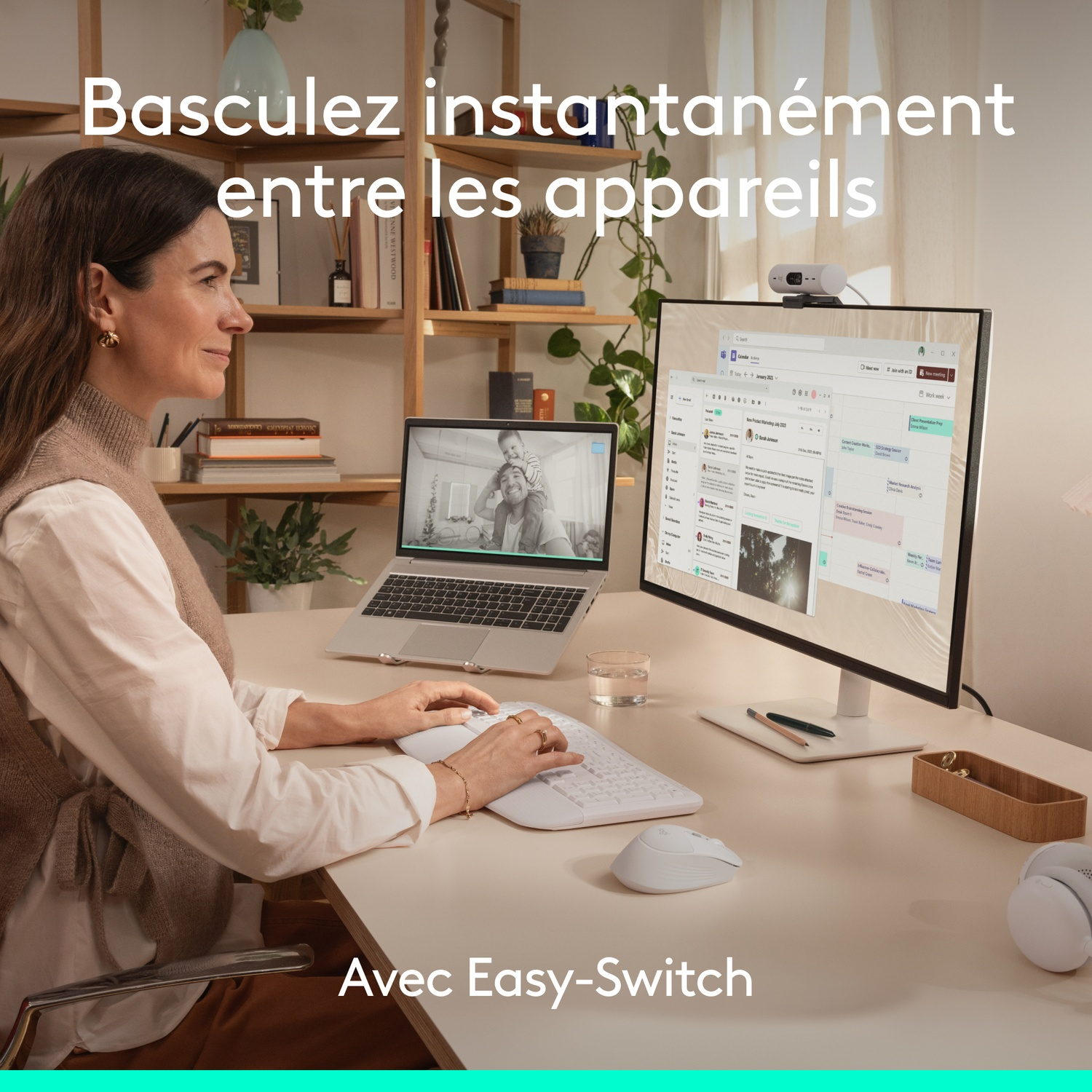 Une femme travaille à un bureau avec deux moniteurs et un clavier.