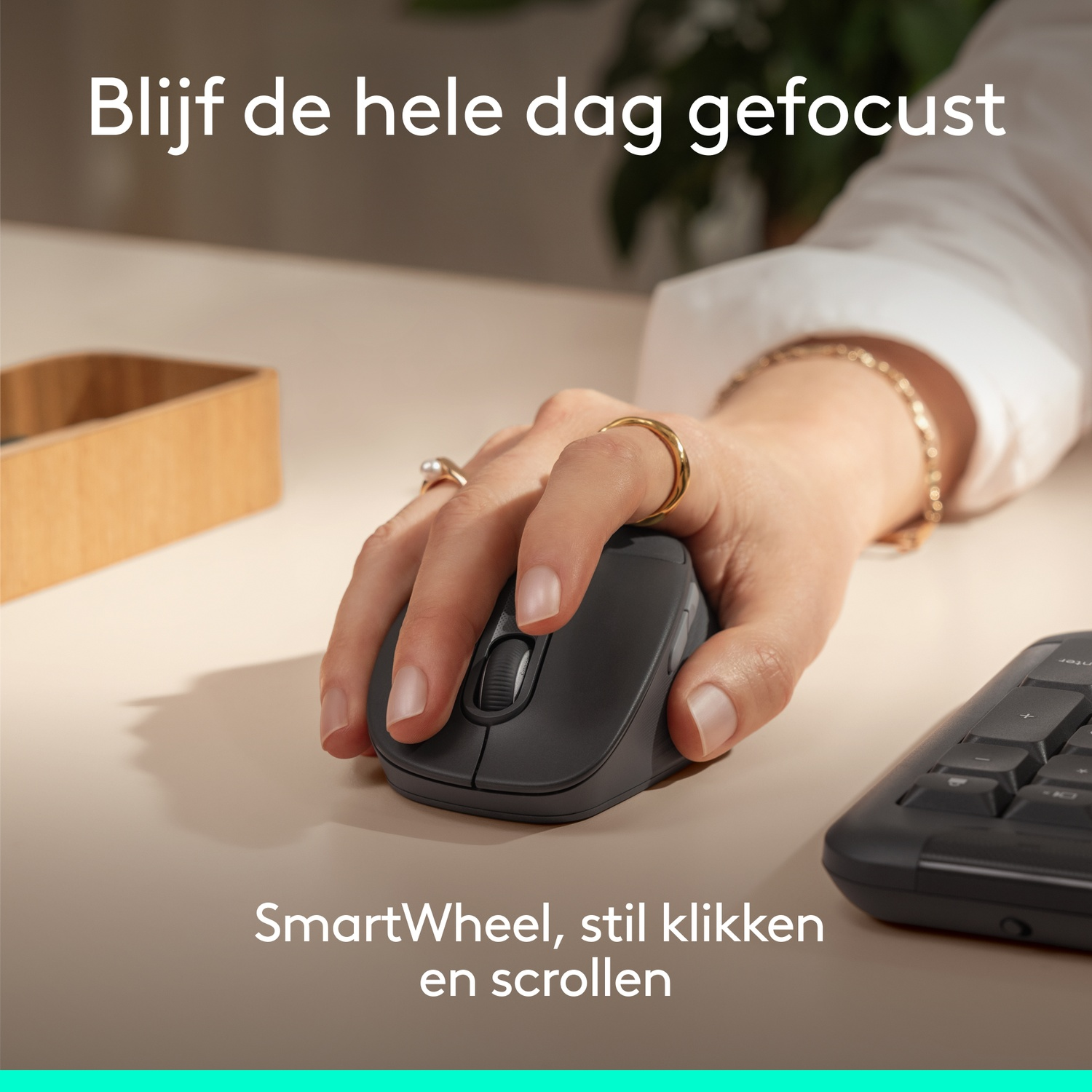 A hand operates a dark mouse with a wheel. Part of a keyboard is visible.
