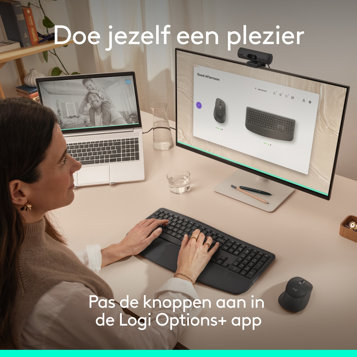 A woman types on a keyboard, a laptop and monitor show Logitech devices.