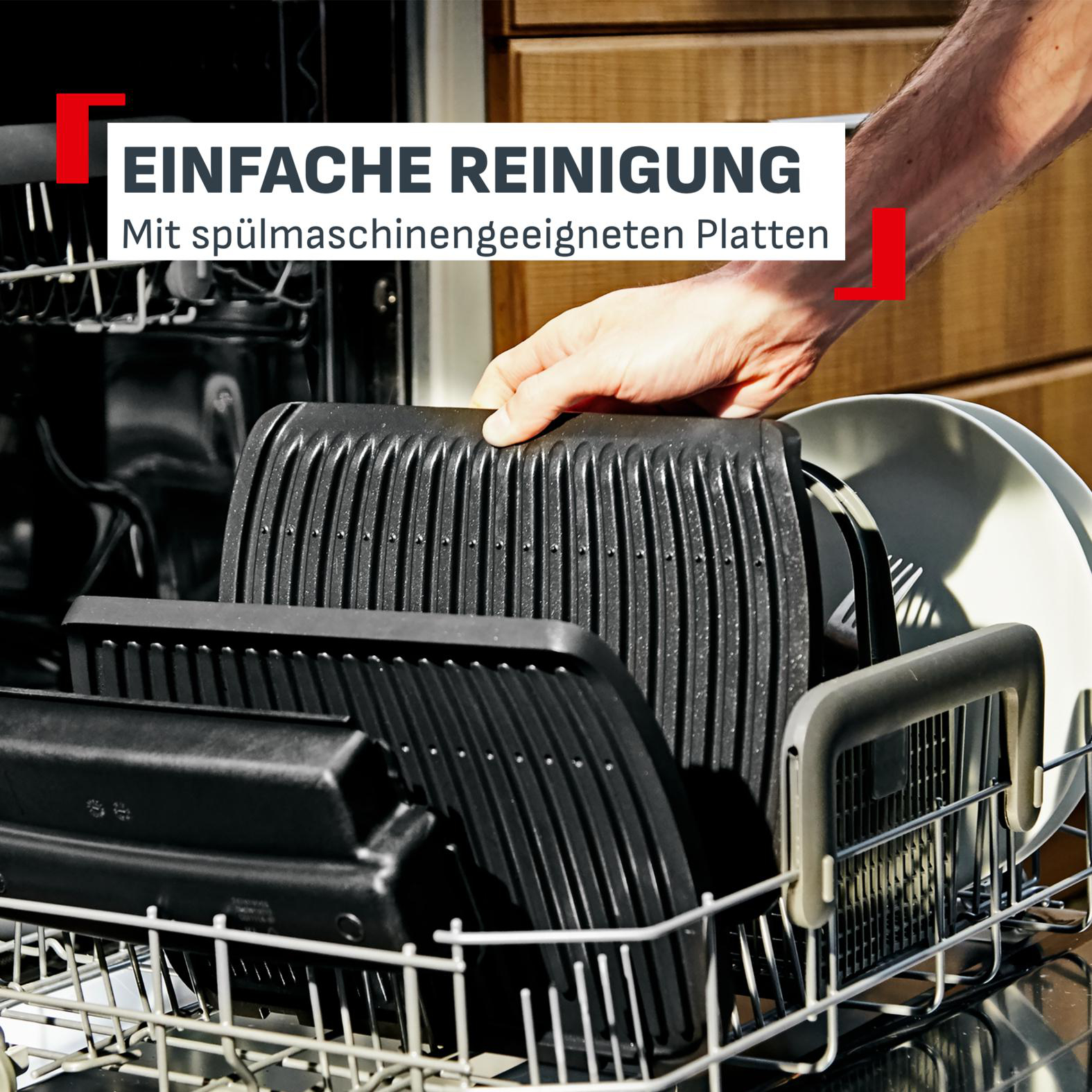 Eine Hand legt Grillplatten in einen Geschirrspüler.