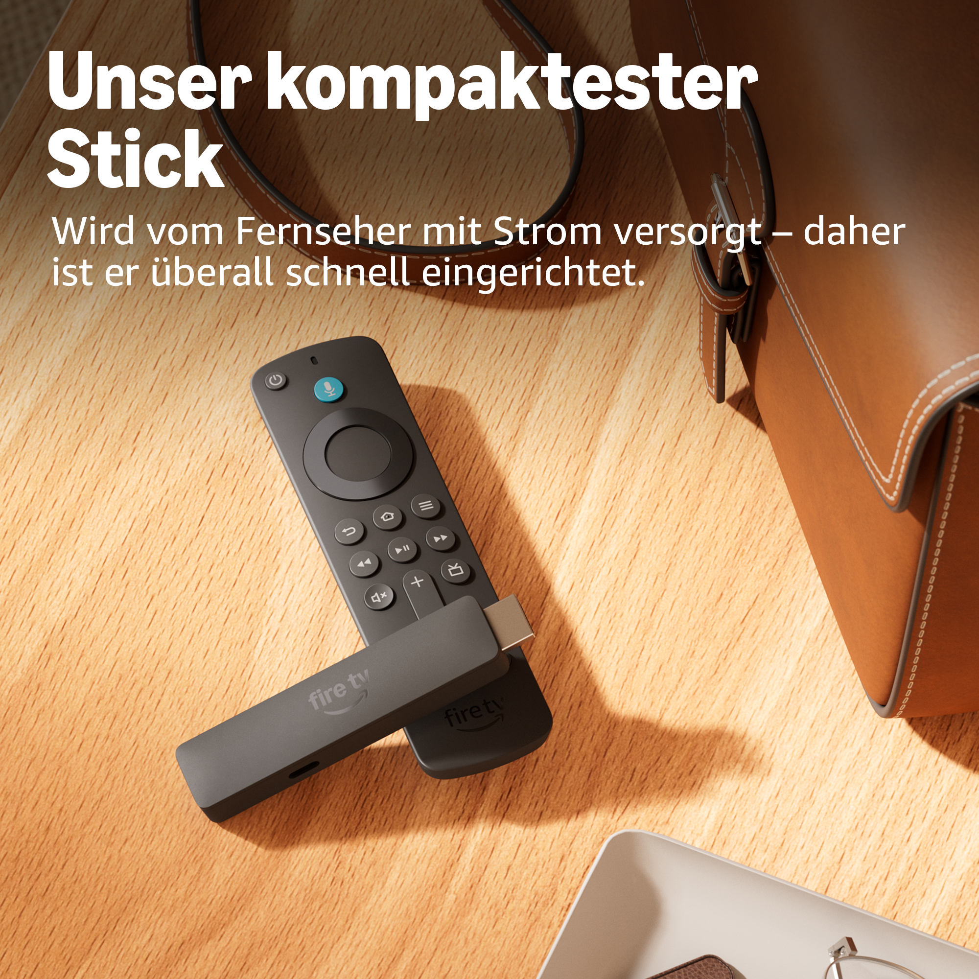 Ein schwarzer Fire TV Stick und eine Fernbedienung liegen auf einem Holztisch.