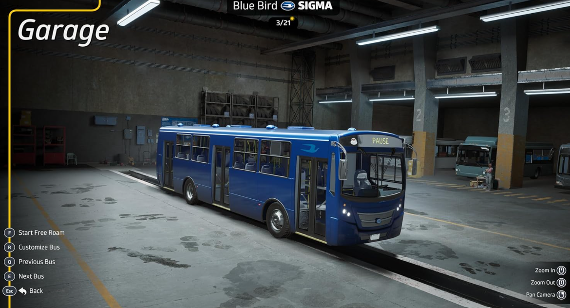 Ein blauer Bus steht in einer Werkstatt mit anderen Bussen im Hintergrund.