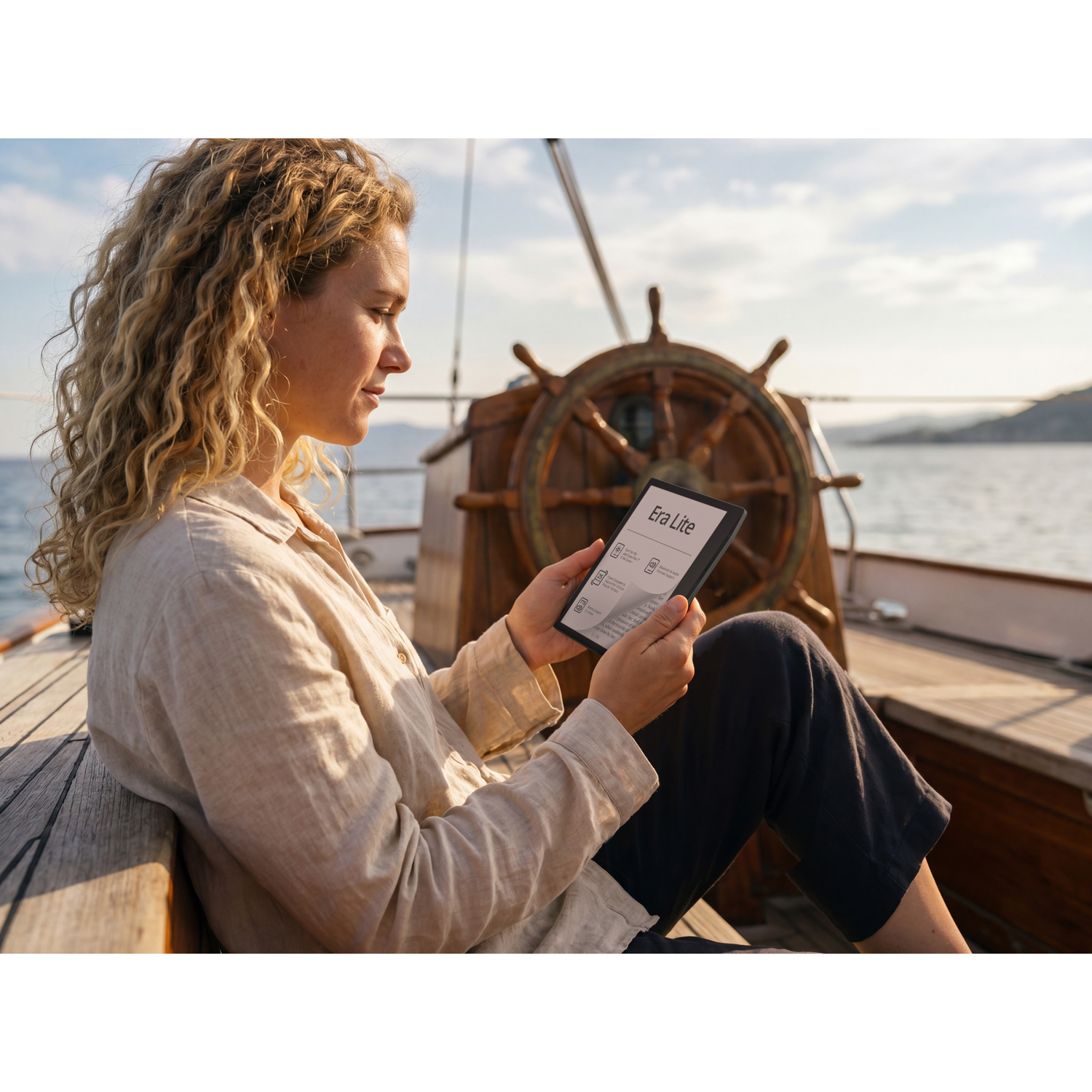 Vrouw leest e-reader op zeilboot met scheepsroer op achtergrond.