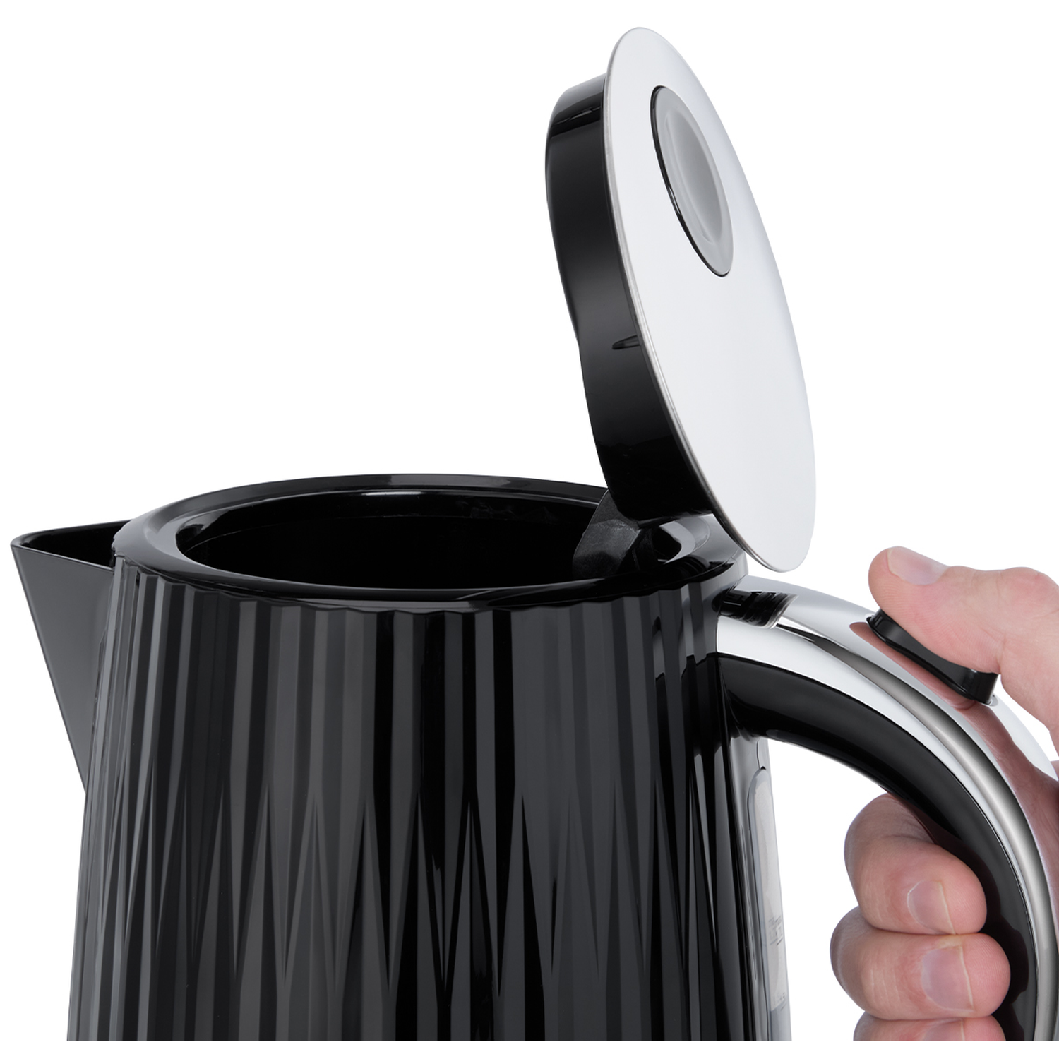 A hand presses the button of a black kettle with its lid open.