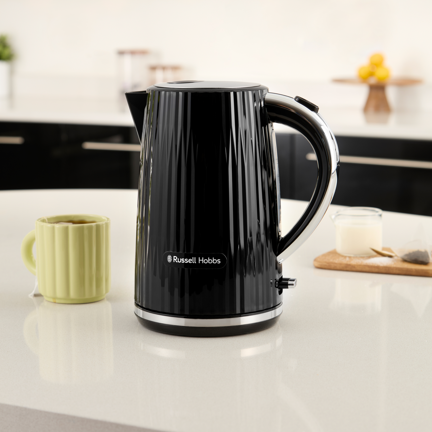 A black Russell Hobbs kettle with a fluted design on a kitchen counter.