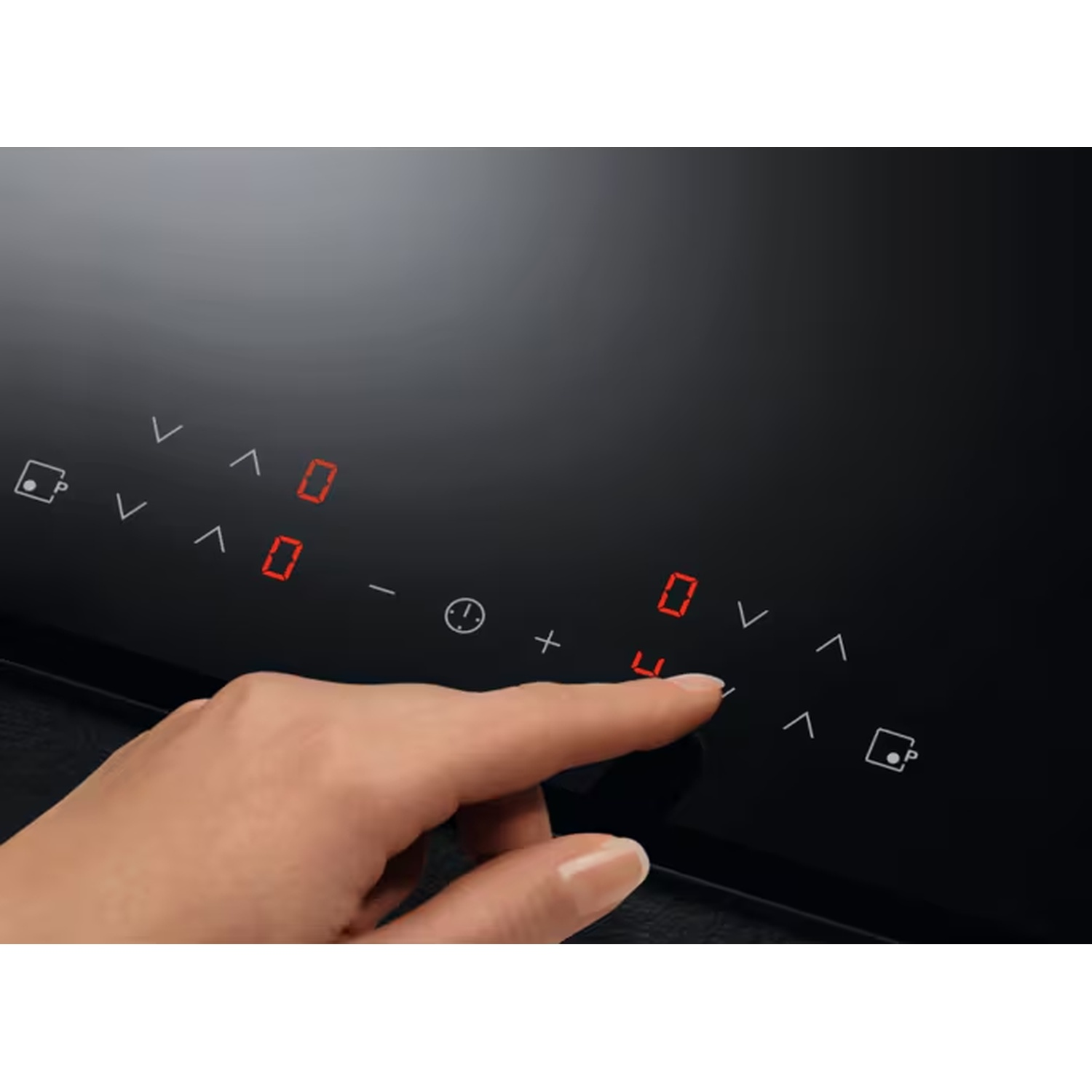 Une main touche le panneau de commande d'une plaque à induction avec des chiffres rouges.