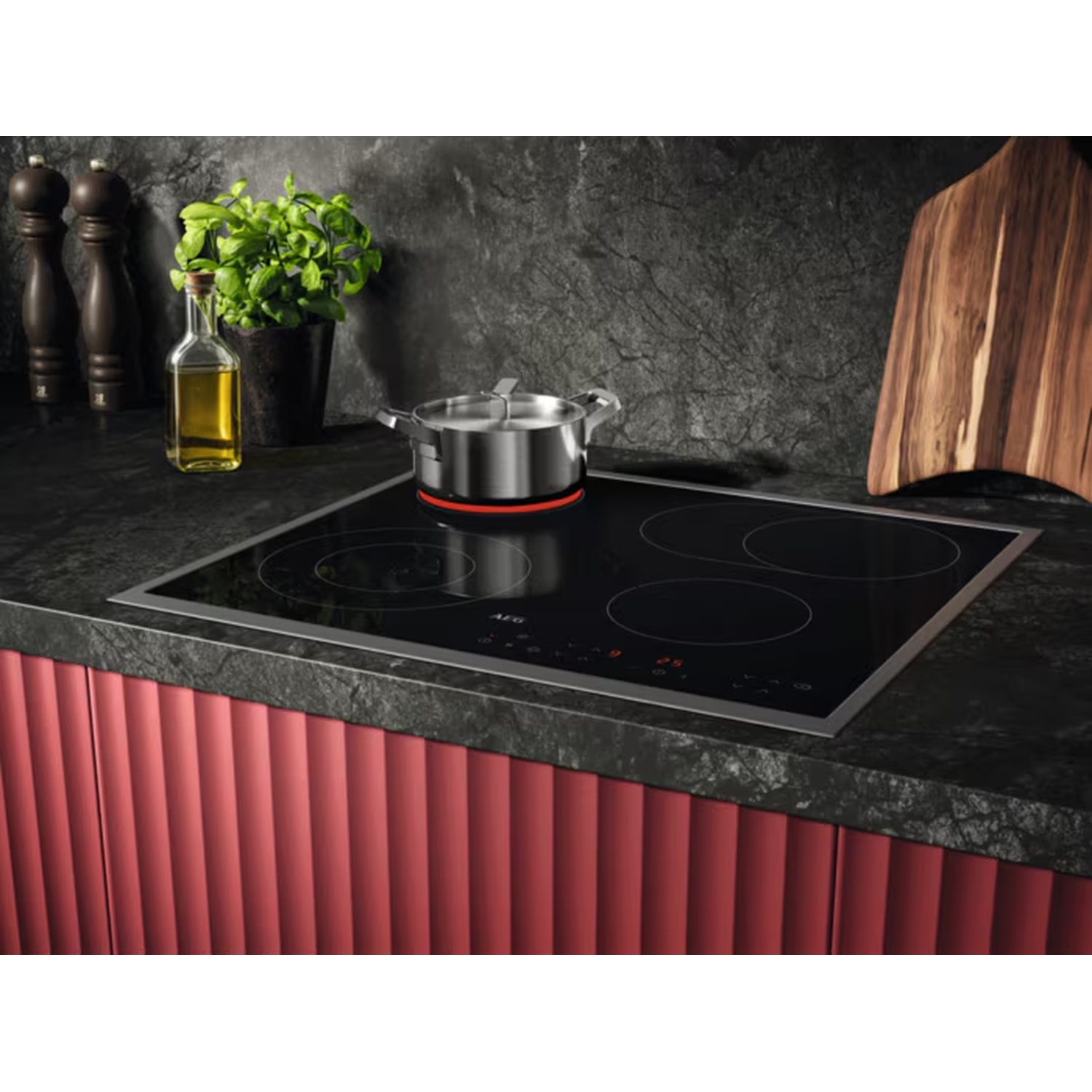 Plaque à induction moderne avec quatre zones de cuisson et une casserole argentée.