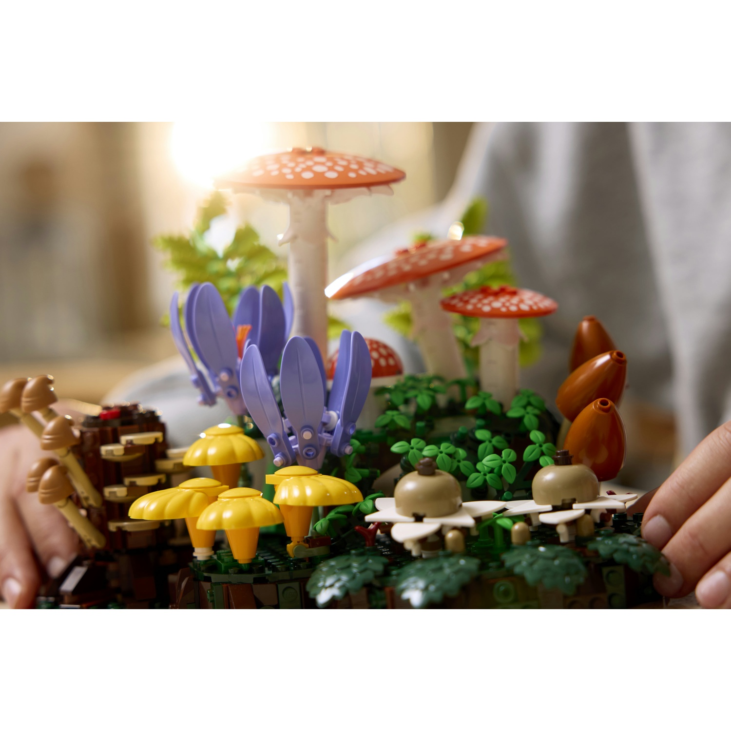 Un giardino di funghi Lego con fiori rossi, gialli e viola, e funghi marroni.