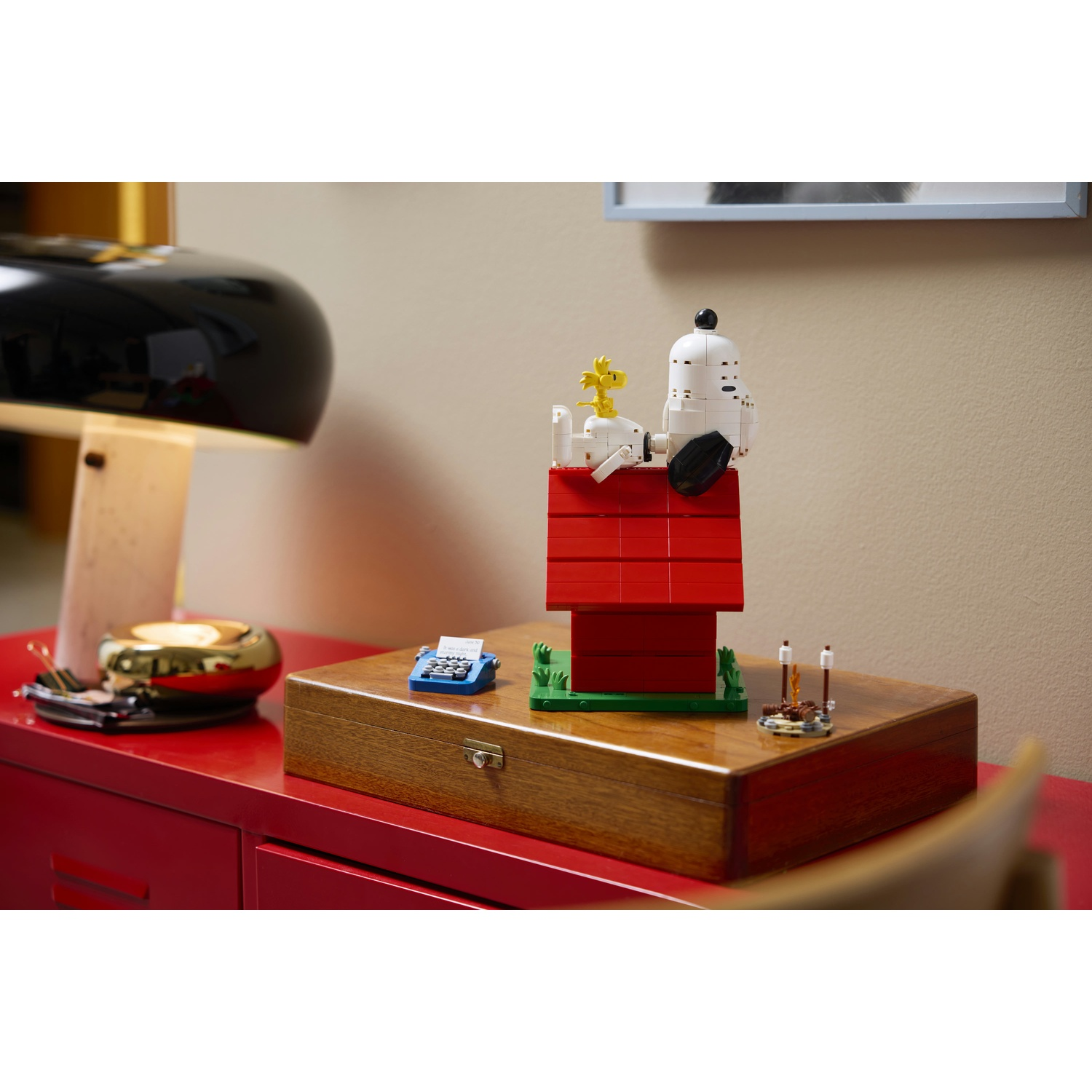 Un modello Lego di Snoopy e Woodstock su un set di cuccia rossa.