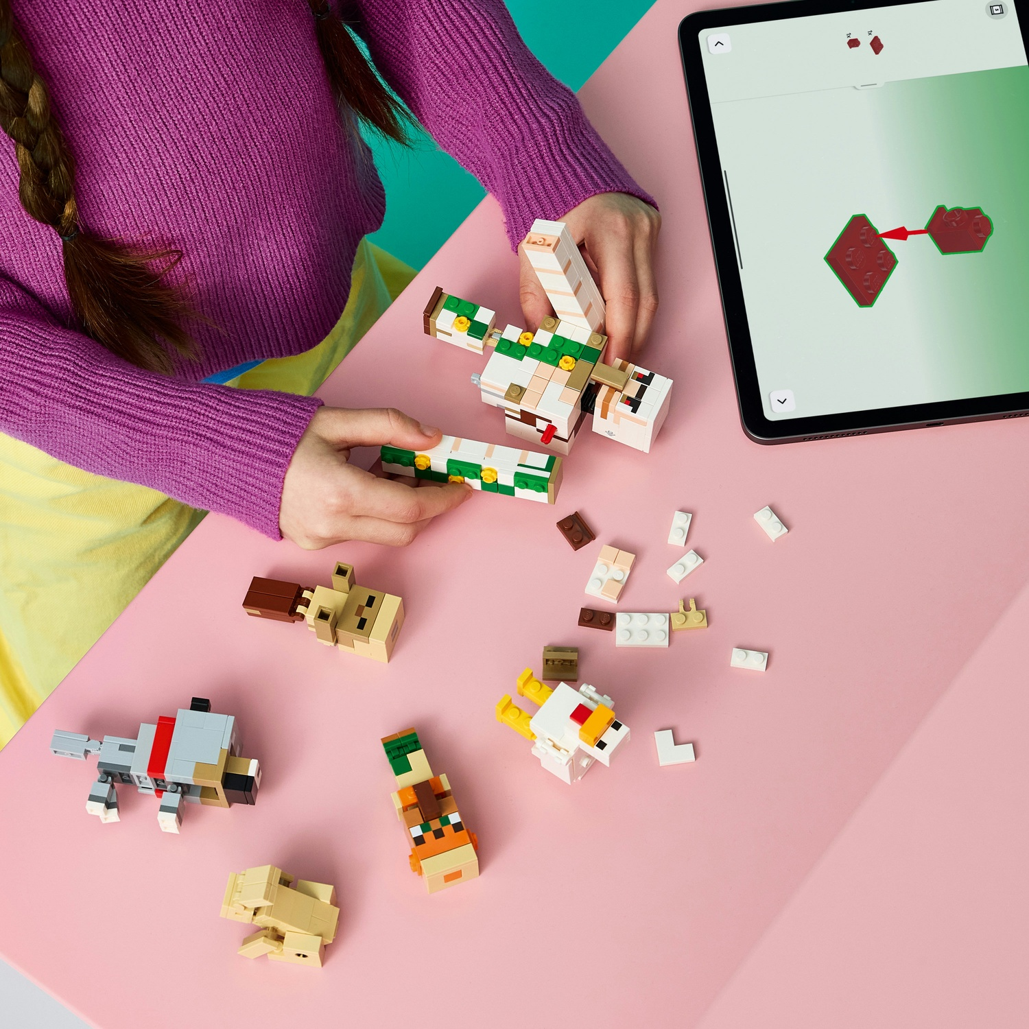Bambino costruisce figure Lego, istruzioni su tablet.