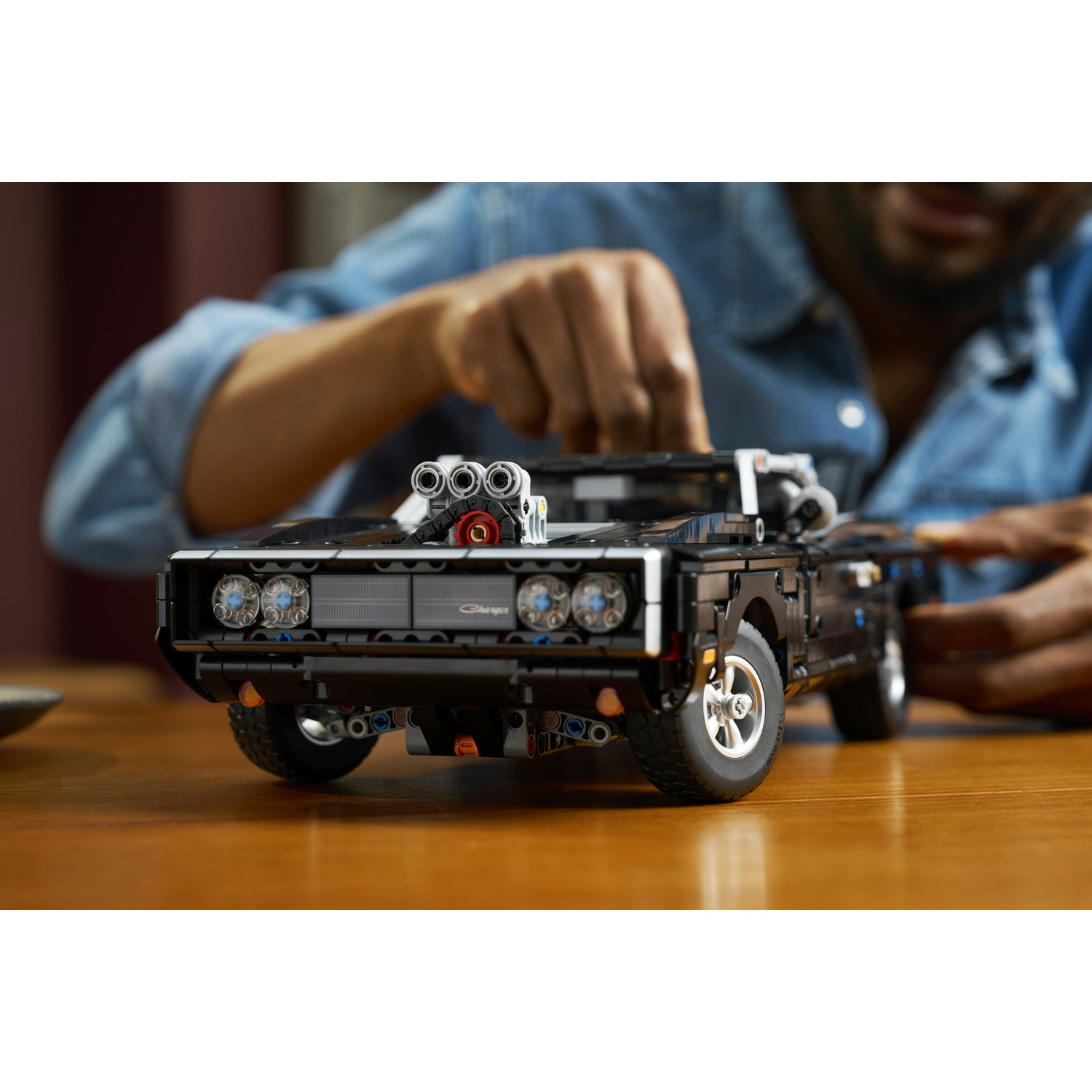 Un uomo costruisce una Dodge Charger Lego nera con motore V8.