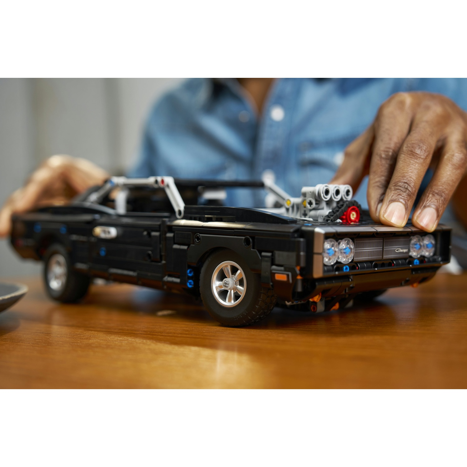 Un modello LEGO nero di una Dodge Charger con motore V8 e ruote argentate.