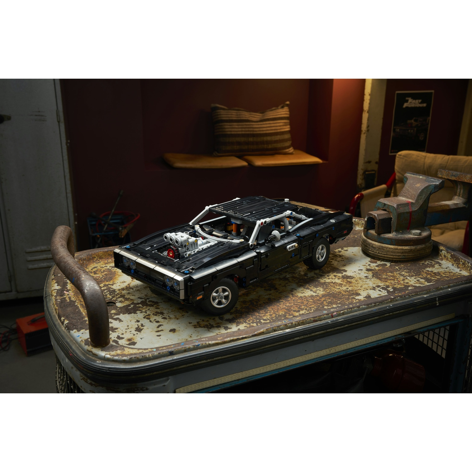 Un modello LEGO nero di una Dodge Charger è su un carrello arrugginito.