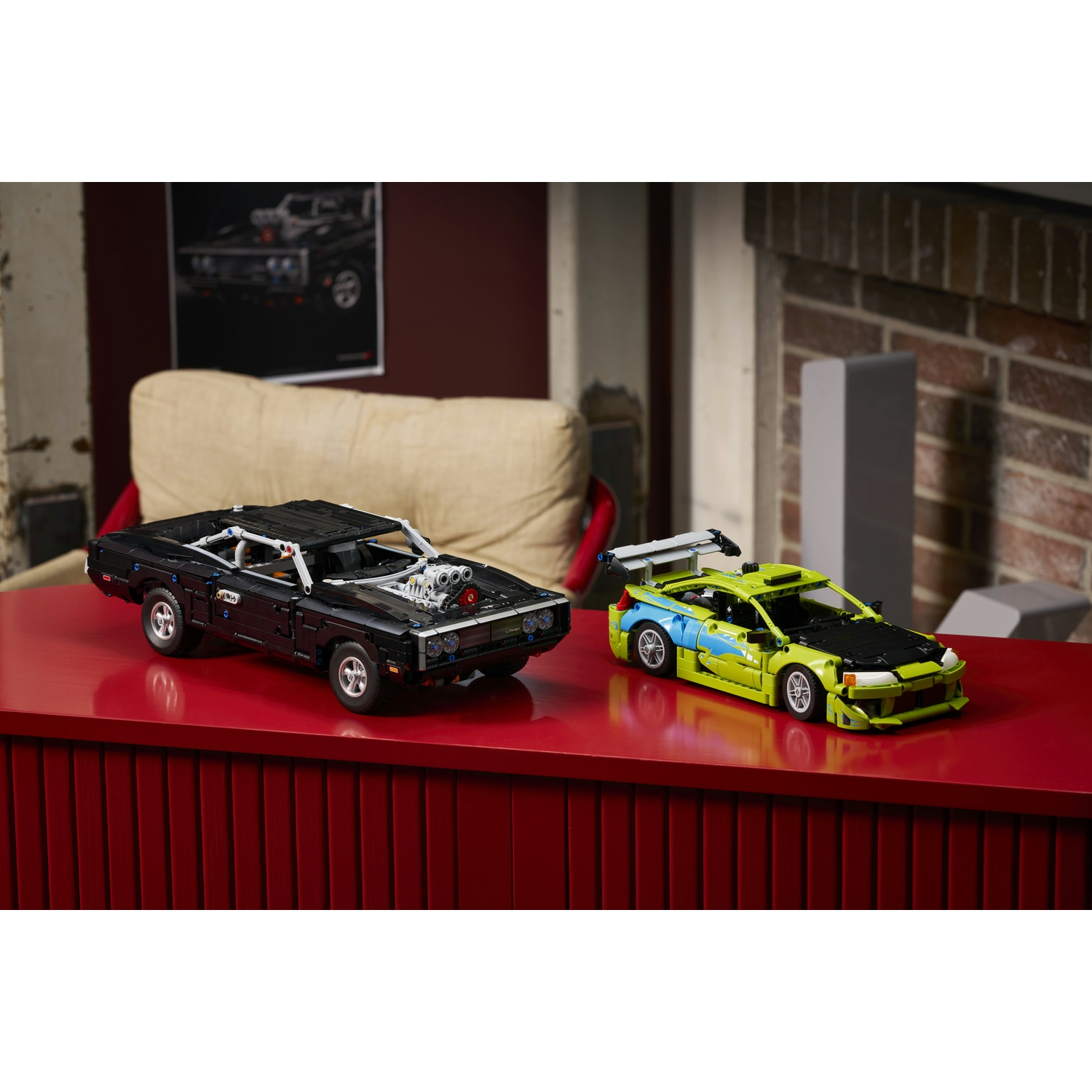 Due modelli di auto Lego, una Dodge Charger nera e un'auto da rally verde, su una superficie rossa.