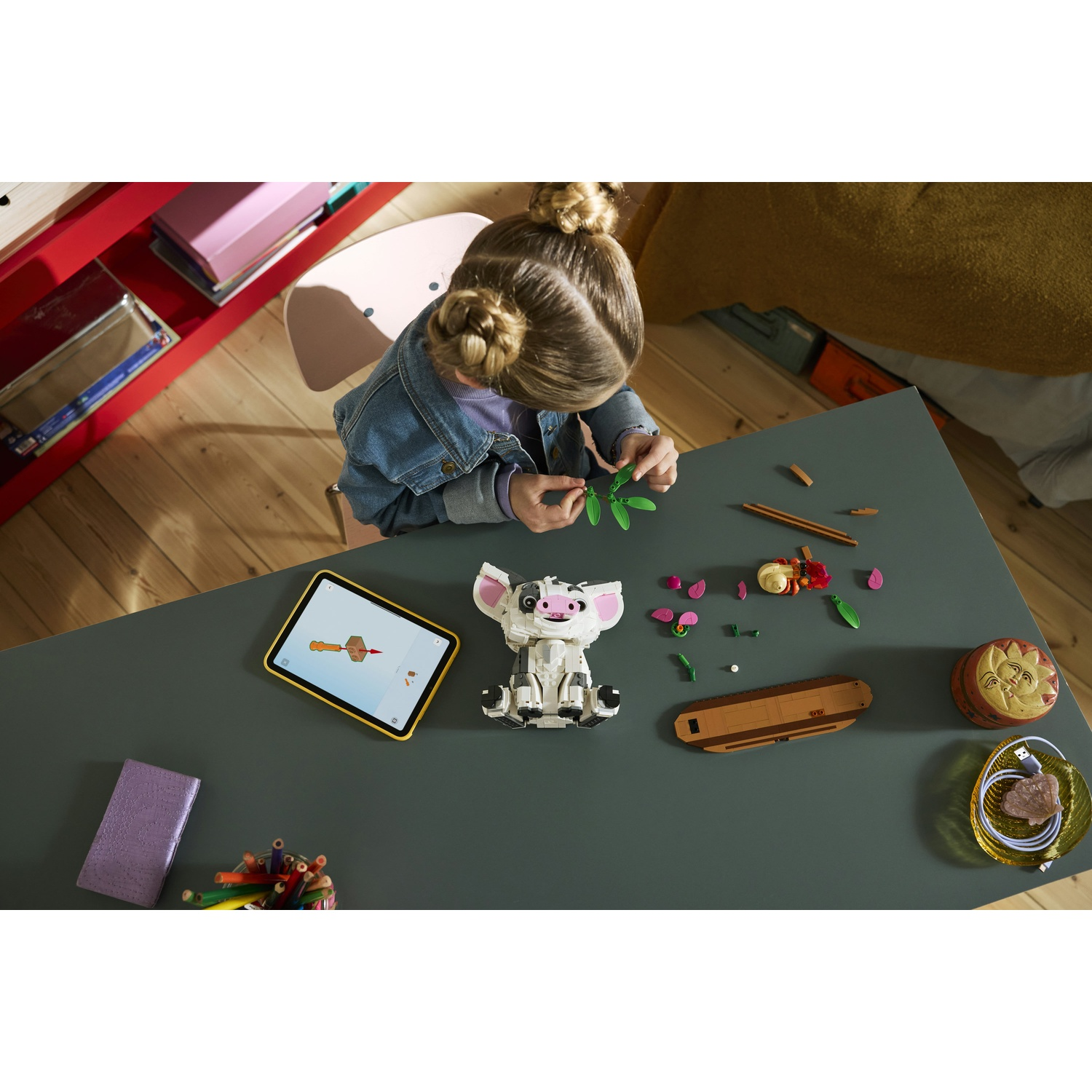Un bambino costruisce con i Lego, con un tablet che mostra le istruzioni nelle vicinanze.