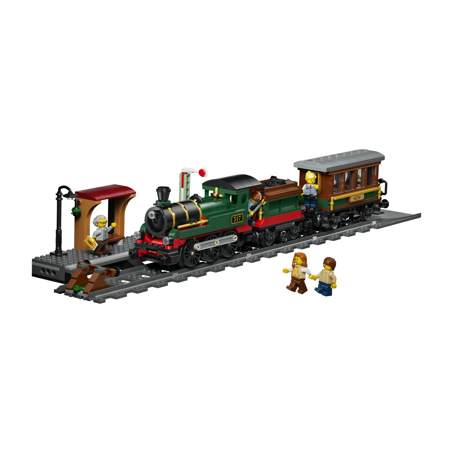 Un treno Lego verde con carrozze è sui binari vicino a una piattaforma.