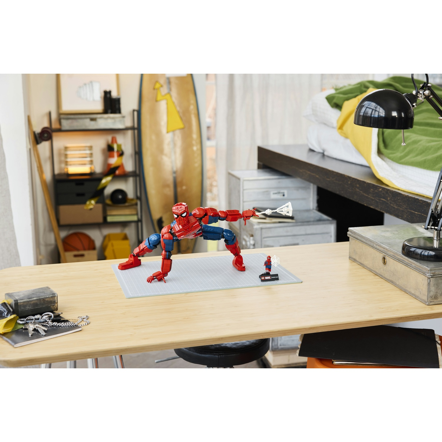 Una figura di Spiderman su una scrivania con un modello più piccolo accanto.