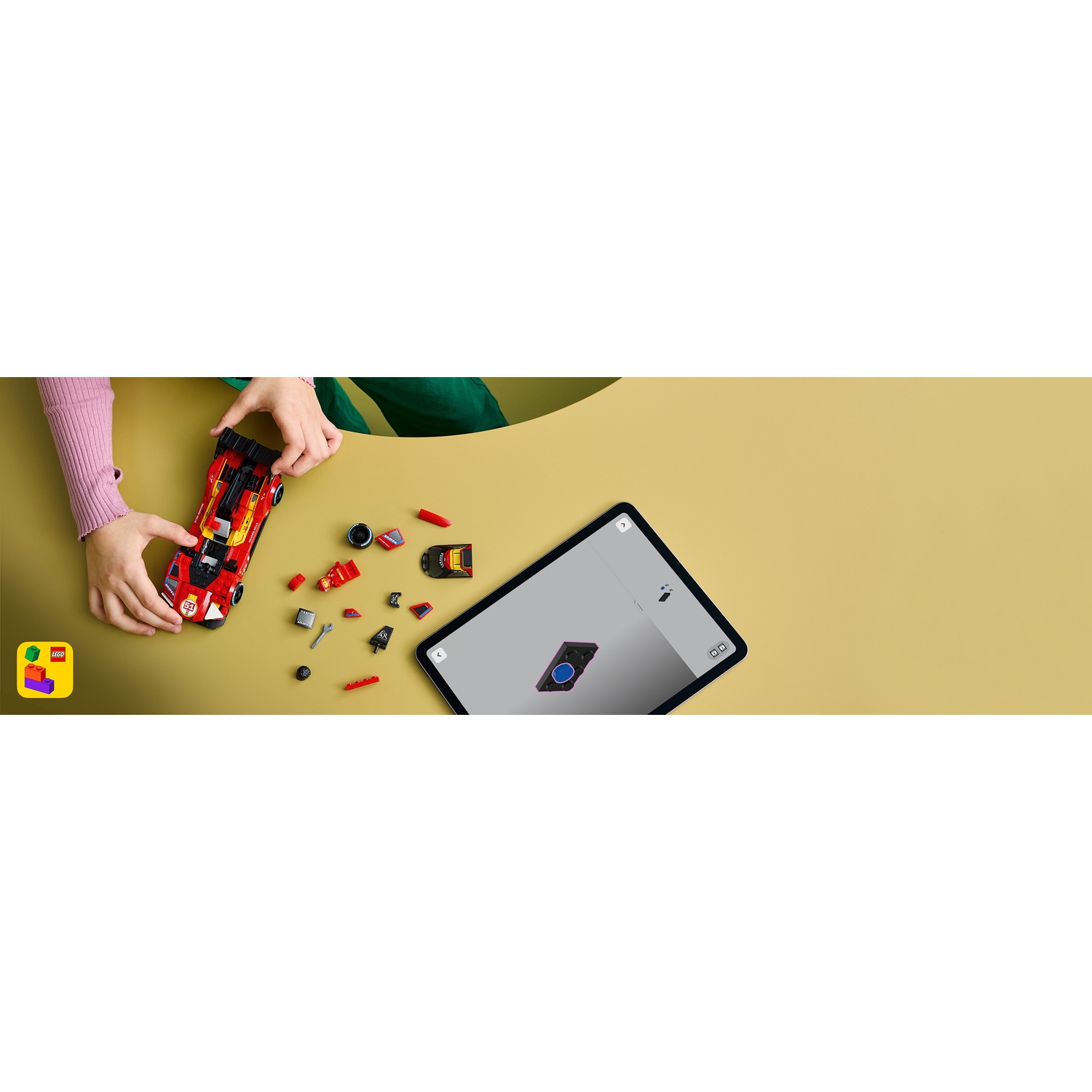 Mani costruiscono un'auto da corsa Lego rossa su un tavolo con istruzioni su tablet.