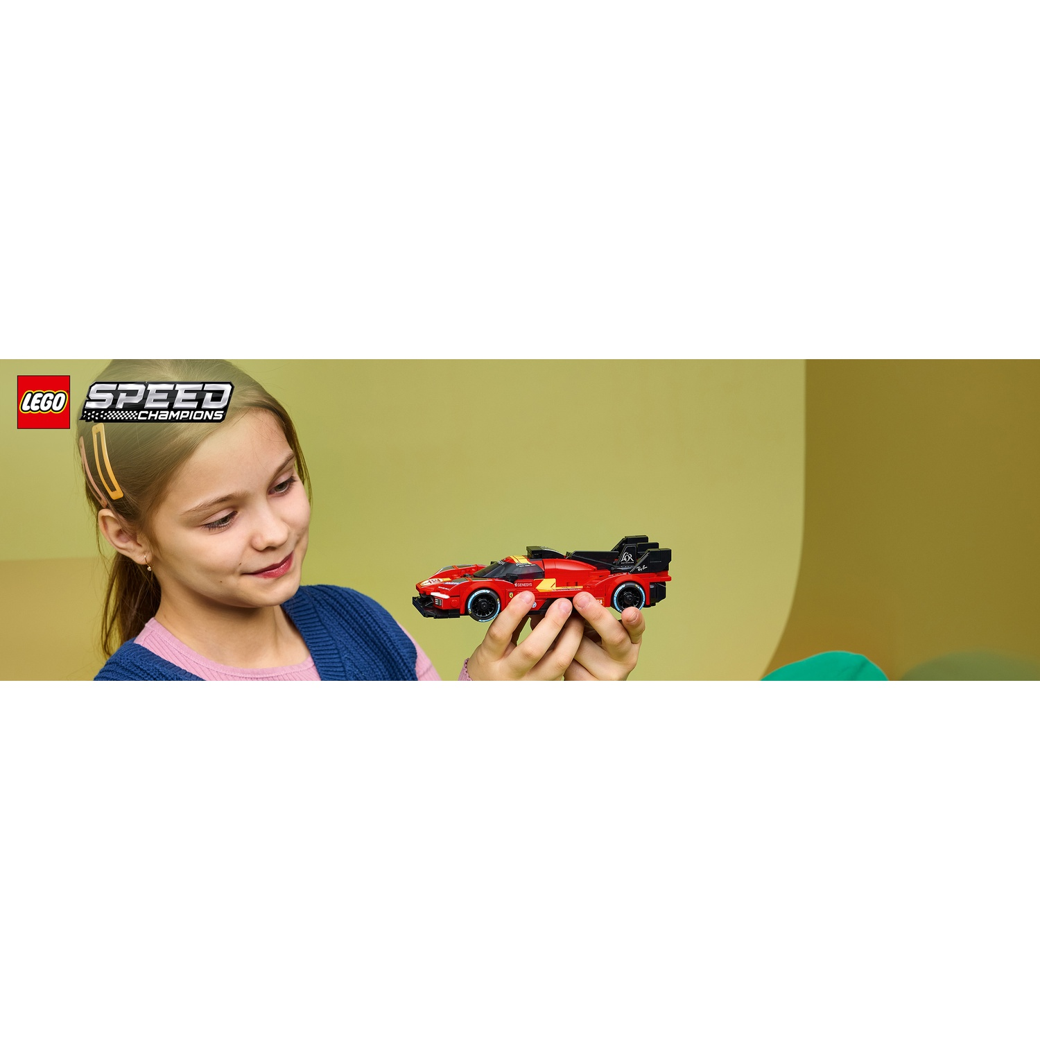 Una bambina tiene una macchina da corsa Lego Speed Champions rossa.