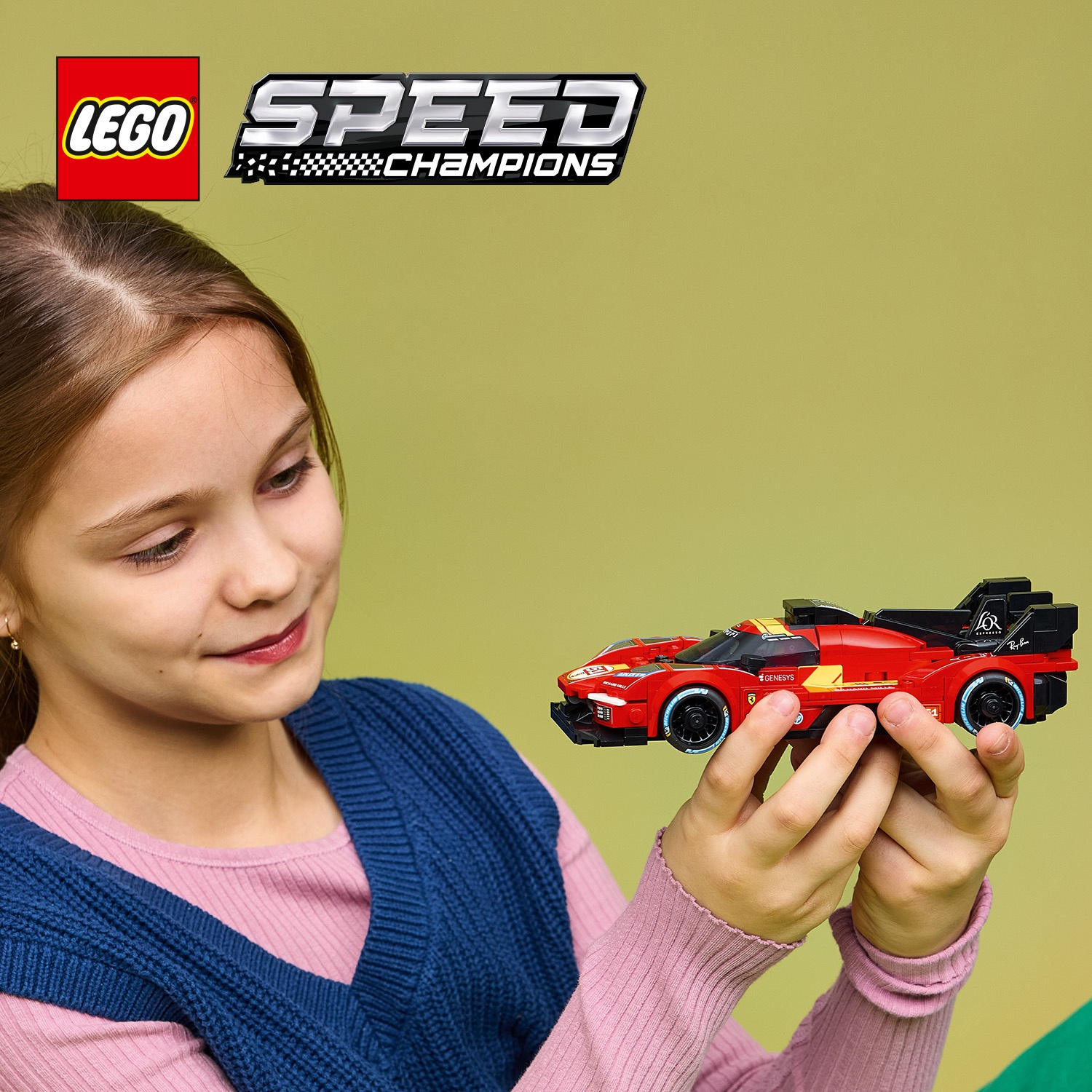 Una ragazza tiene un'auto da corsa Lego rossa su sfondo verde chiaro.