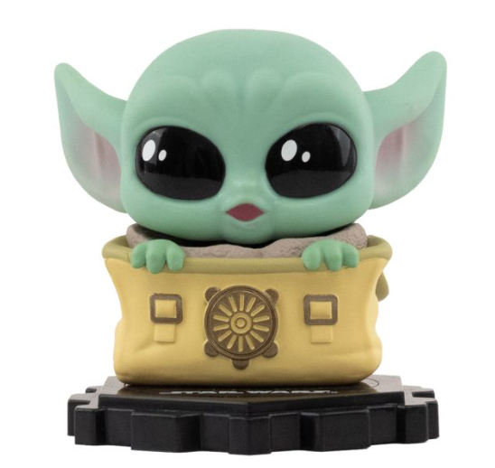 Baby Yoda Figur in einer gelben Tasche mit Emblem, auf schwarzem Sockel.