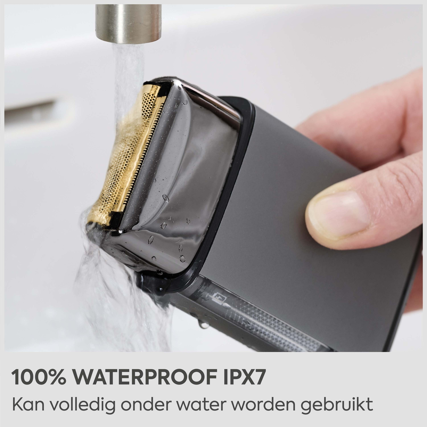 Een elektrische scheerapparaat wordt afgespoeld onder stromend water in een gootsteen.