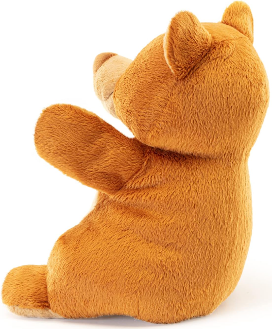 Ein brauner Teddybär sitzt aufrecht und blickt nach links. Seine Pfote ist erhoben.