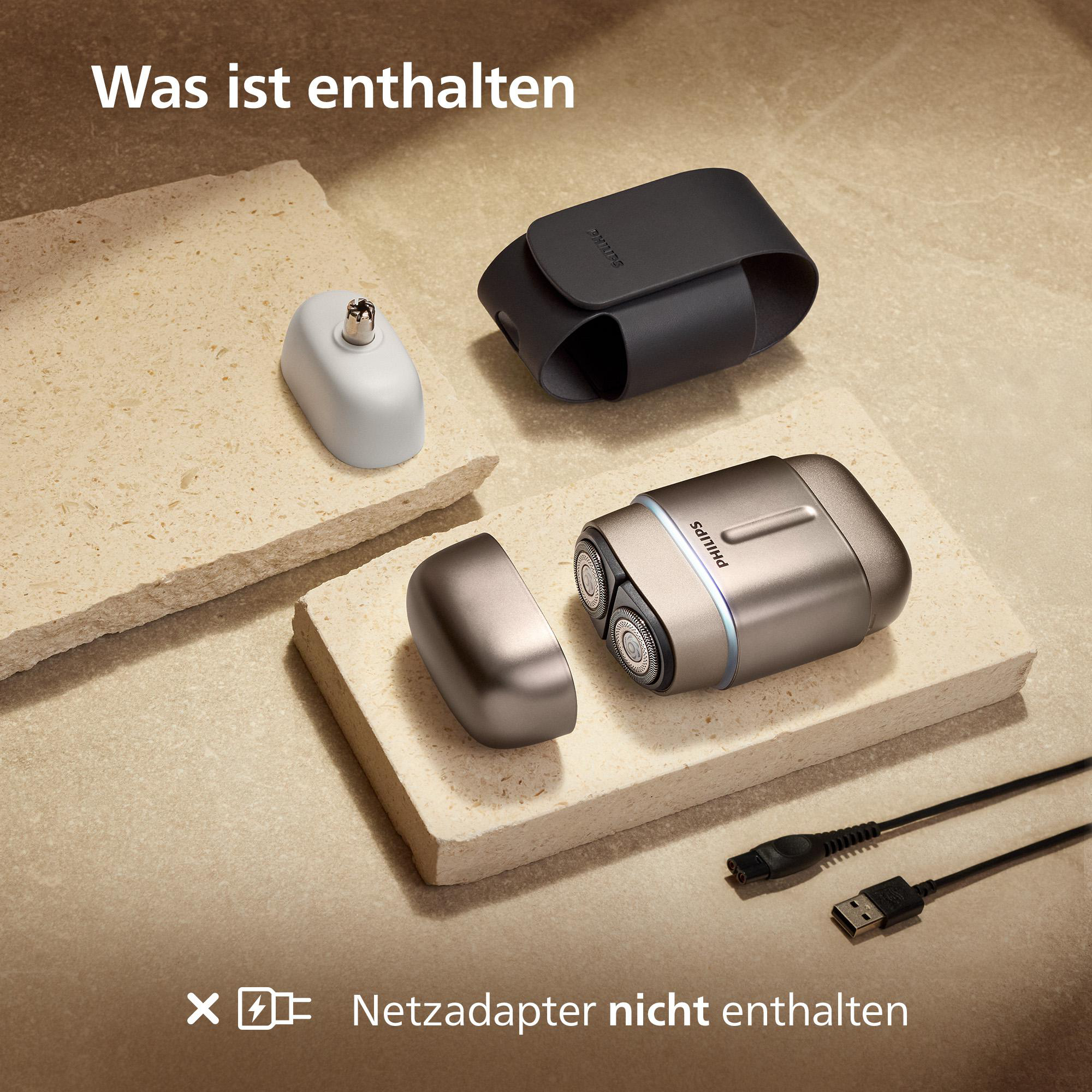 Ein Philips Rasierer mit Zubehör auf Steinplatten. Netzadapter nicht enthalten.